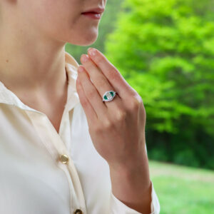 Art Deco Inspired Oval Diamond and Emerald Haloed Three Stone