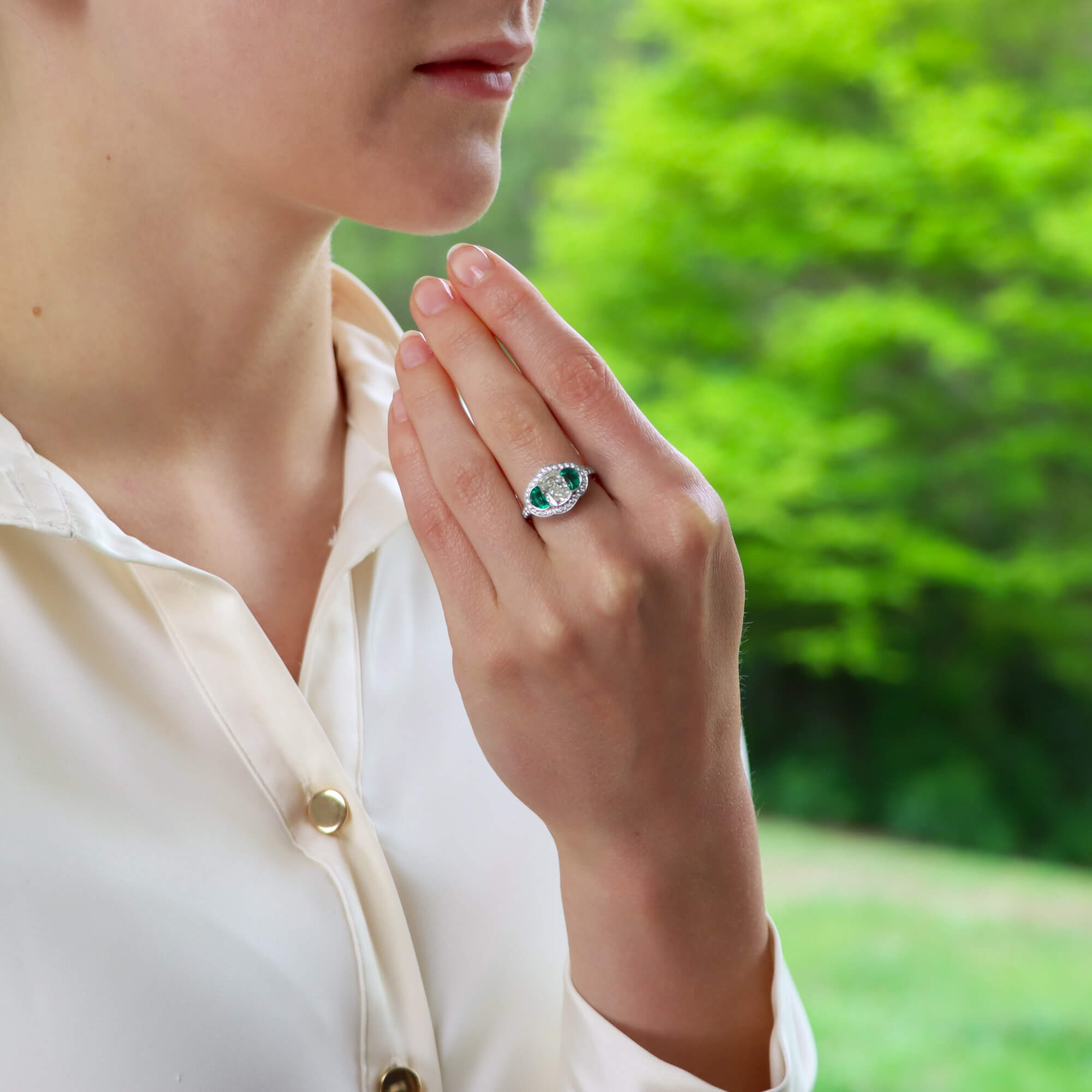 Art Deco Inspired Oval Diamond and Emerald Haloed Three Stone at