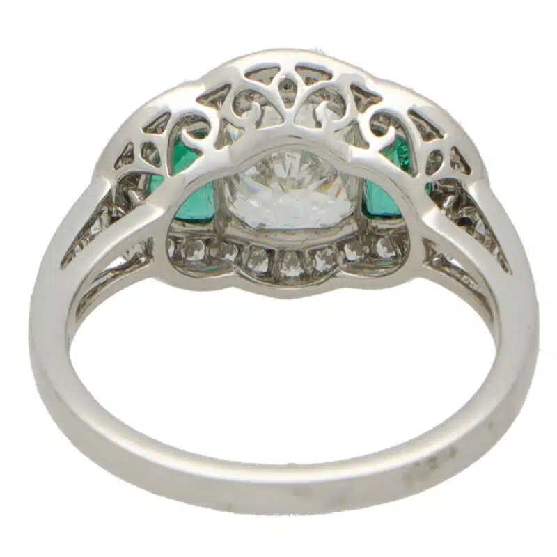 Art Deco Inspired Oval Diamond and Emerald Haloed Three Stone