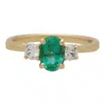 Contemporary Oval Emerald and Round Cute Diamond Three Stone