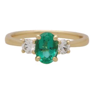 Contemporary Oval Emerald and Round Cute Diamond Three Stone
